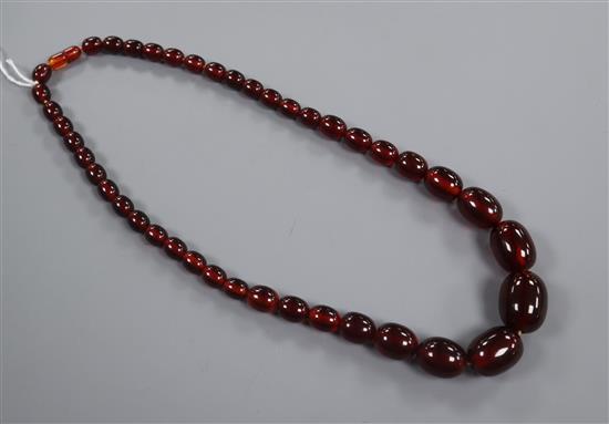 A single strand graduated simulated cherry amber necklace, gross 75 grams, 60cm.
